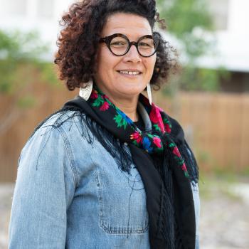 Femme brune avec des lunettes aux cheveux frisés